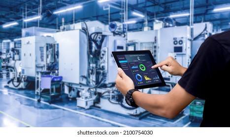 Smart Industry Control Concept.Hands Holding Tablet On Blurred Automation Machine As Background