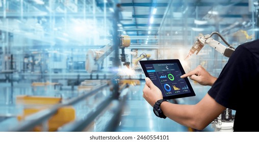 Smart industry control concept.Hands holding tablet on blurred automation machine as background - Powered by Shutterstock