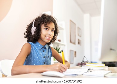 Smart Little African Girl Fill In Exercise Book, Watching Video Classes, Training For An Exam, Researching Topic For Essay, Studying On The Distance, Doing Homework. Studying And Technology