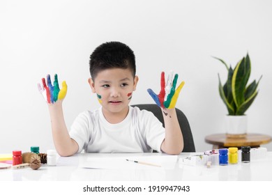 Smart Little Asian Boy Having An Idea While With Painted Hands At Home. Learning And Education Of Kid