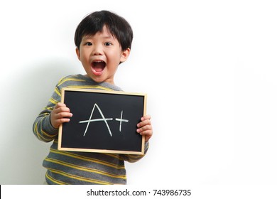 Smart Little Asian Boy Holding A Chalk Board With The A+ Sign On White Background