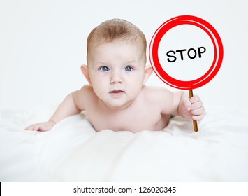 Smart little boy holding a sign "STOP" in the hands