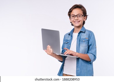 Smart little boy with laptop in casual clothes isolated over white background