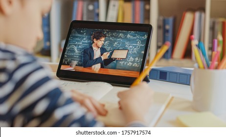 Smart Little Boy Uses Digital Tablet for Video Call with His Teacher. Screen Shows Online Lecture with Teacher Explaining Subject from a Classroom. E-Education Distance Learning, Homeschooling