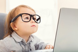 Smart Little Toddler Girl Wearing Big Glasses While Using Her Laptop