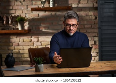 Smart looking older business man working in home office using laptop computer. - Shutterstock ID 1864138822