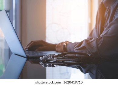 Smart Male Doctor Hand Using Wireless Mouse, Browsing Medical Information On Laptop Computer With Medical At Office. Medic Tech, Telehealth , Online Medical, Emr, Ehr Or Telemedicine Concept. 