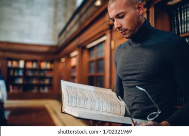 Smart Male Historian Concentrated On Scientific Research Working With Literature In Archive, Clever Young Professor Reading Book In Public Library Using Information For Intellectual Project