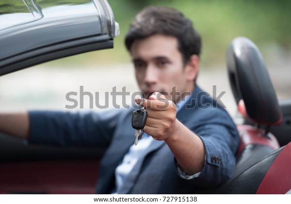 smart man showing\
car key from in car sport