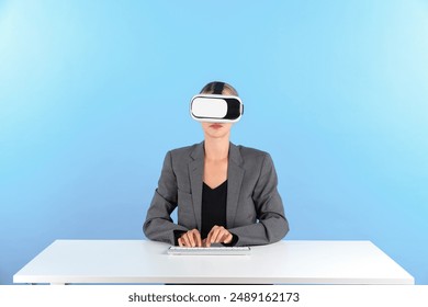 Smart manager wearing VR glasses while sitting at table with keyboard. Businesswoman pointing to manage data analysis while using suit and visual reality headset and enter in metaverse. Contraption. - Powered by Shutterstock