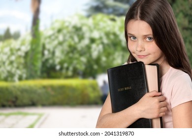 Smart And Nerd Kid Girl Holding Bible For Study In Church.