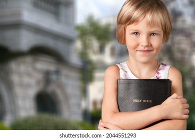 Smart And Nerd Kid Girl Holding Bible For Study In Church.