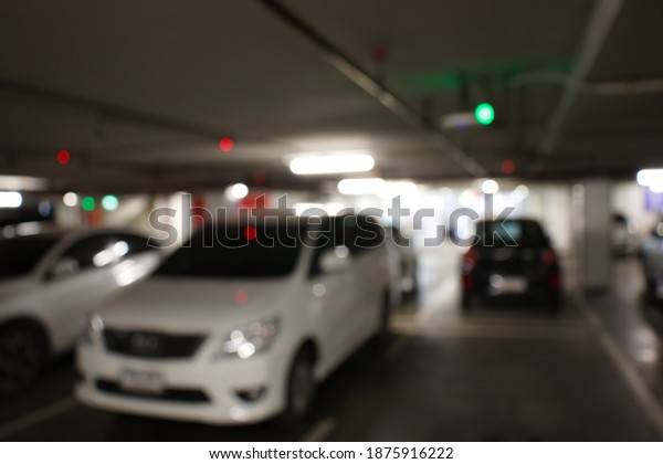 Smart parking guidance in department\
store with light overhead. Car lot. Blurred\
background.