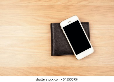 Smart Phone And Black Wallet On Wooden Floor Background. Top View