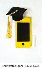 Smart Phone As Blackboard With Chalk And Graduation Academic Cap Top View On White Background