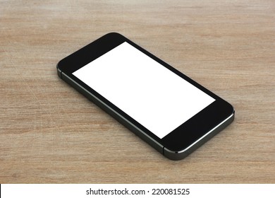 Smart phone with blank screen lying on wooden table.