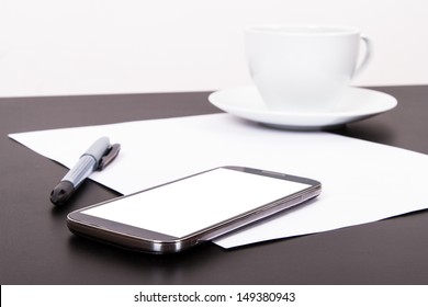 Smart phone with blank, white screen, ceramic coffee cup, pen and empty paper on wooden table, isolated on white background. - Powered by Shutterstock