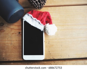 Smart Phone With Christmas Hat And Bluetooth Speaker