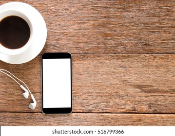 Smart phone and Earphone with coffee on wooden floor.Top view focus. - Shutterstock ID 516799366