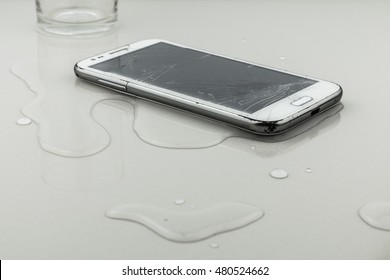 Smart phone fail broken on tile floor with water spilled
