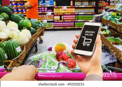 Smart phone with grocery shopping online on screen over blur supermarket background, retail business and technology concept