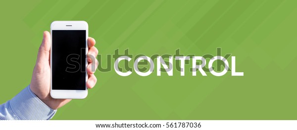 Smart phone in hand front of green background and\
written CONTROL