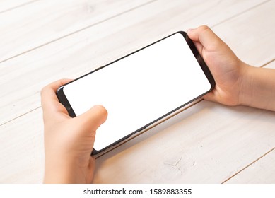 Smart Phone Mockup In Kid Hands In Horizontal Position. Isolated Screen In White For Promote Game Or Mobile App