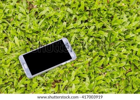 Smart phone on green grass background