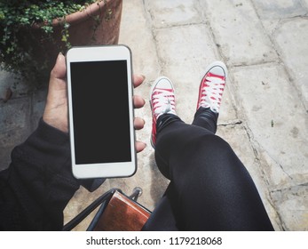 Smart phone on hand and red sneakers