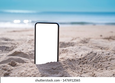 Smart Phone On Tropical Sand Beach With Bokeh Sun Light, Wave Texture And Blue Sky Background. White Screen Display  Mock Up For Text, Ads Design. Technology And Travel Nature Concept With Copy Space.