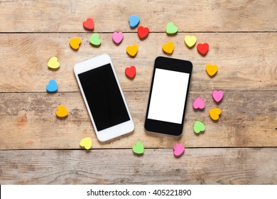 Smart Phone On Wooden Table With Heart Background With Copy Space