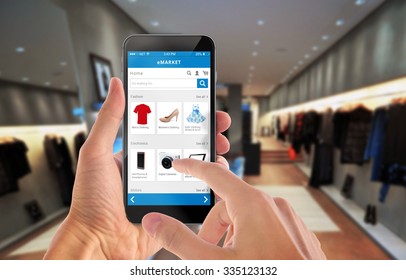 Smart phone online shopping in man hand. Shopping center in background. Buy clothes shoes accessories with e commerce web site