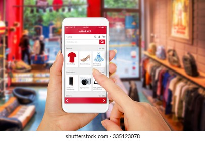 Smart Phone Online Shopping In Woman Hand. Shopping Center In Background. Buy Clothes Shoes Accessories With E Commerce Web Site