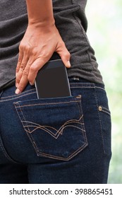 Smart phone in pocket of girl's jeans.