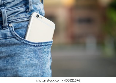 Smart phone in pocket of girl's jeans