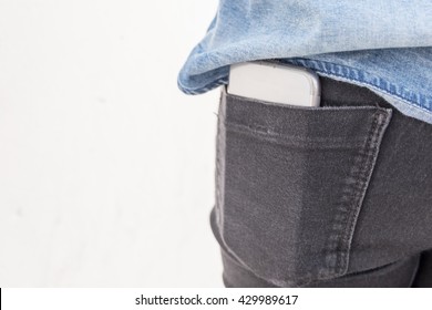 Smart phone in pocket of woman's jeans -copyspace for text