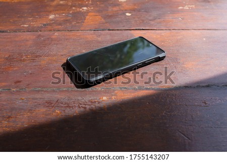 smart phone put in the sun on the wood table making it hot or over heat