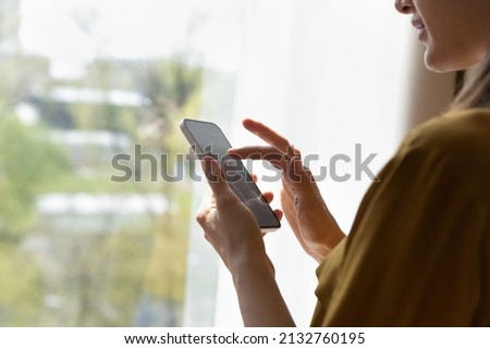 Smart phone screen with empty mock up close up view over female shoulder, user of new mobile application, electronic business app usage, texting message, writes e-mail, distance communication concept