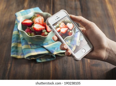 Smart phone shot food photo. Hands taking photo of fresh strawberry - Powered by Shutterstock