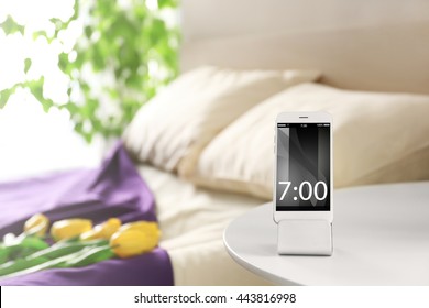 Smart Phone With Stand On A Bedside Table In A Room