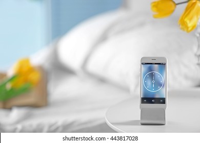 Smart Phone With Stand On A Bedside Table In A Room