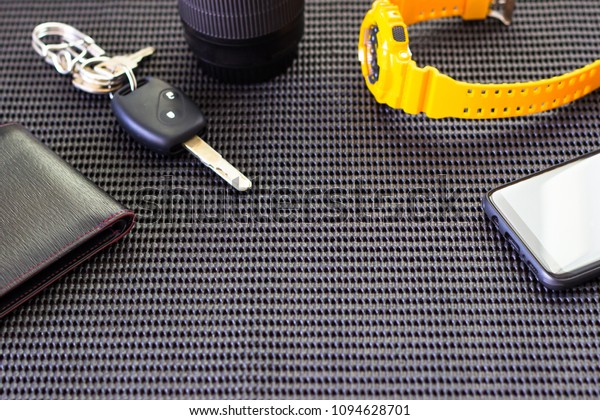 Smart phone Watch key car wallet on the\
foam sheet on table in hotel holiday concept\
