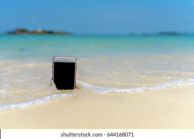  Smart phone with weather app on a sandy beach