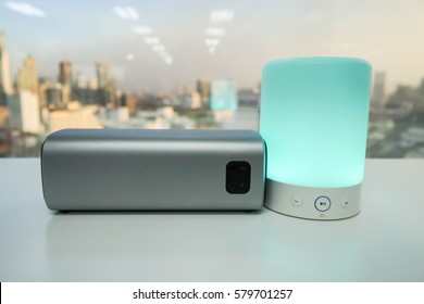 Smart Portable Music Speaker Light In Green Color With Wireless Bluetooth Speaker On Table