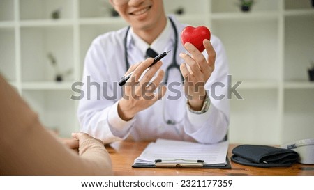 A smart and professional millennial Asian male doctor is explaining a treatment plan and giving information about the disease to a female patient at the hospital.