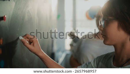 Smart Pupil Showcasing Math Knowledge: Close Up Shot of Elementary School Boy Solving Mathematical Problems Writing on the Chalkboard in Front of Classroom. Female Teacher Checking Correct Answers.