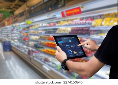 Smart retail management system.Worker hands holding tablet on blurred supermartket as background - Powered by Shutterstock