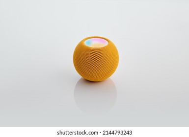Smart round speaker in yellow color isolated on white.