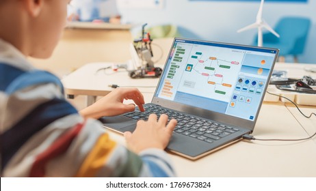 Smart Schoolboy Uses Laptop to Program Software for Robotics Engineering Class. Elementary School Science Classroom with Gifted Brilliant Children Working with Technology - Powered by Shutterstock