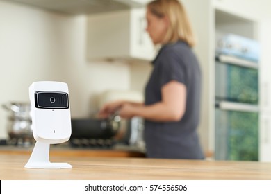 Smart Security Camera In Kitchen As Woman Prepares Meal